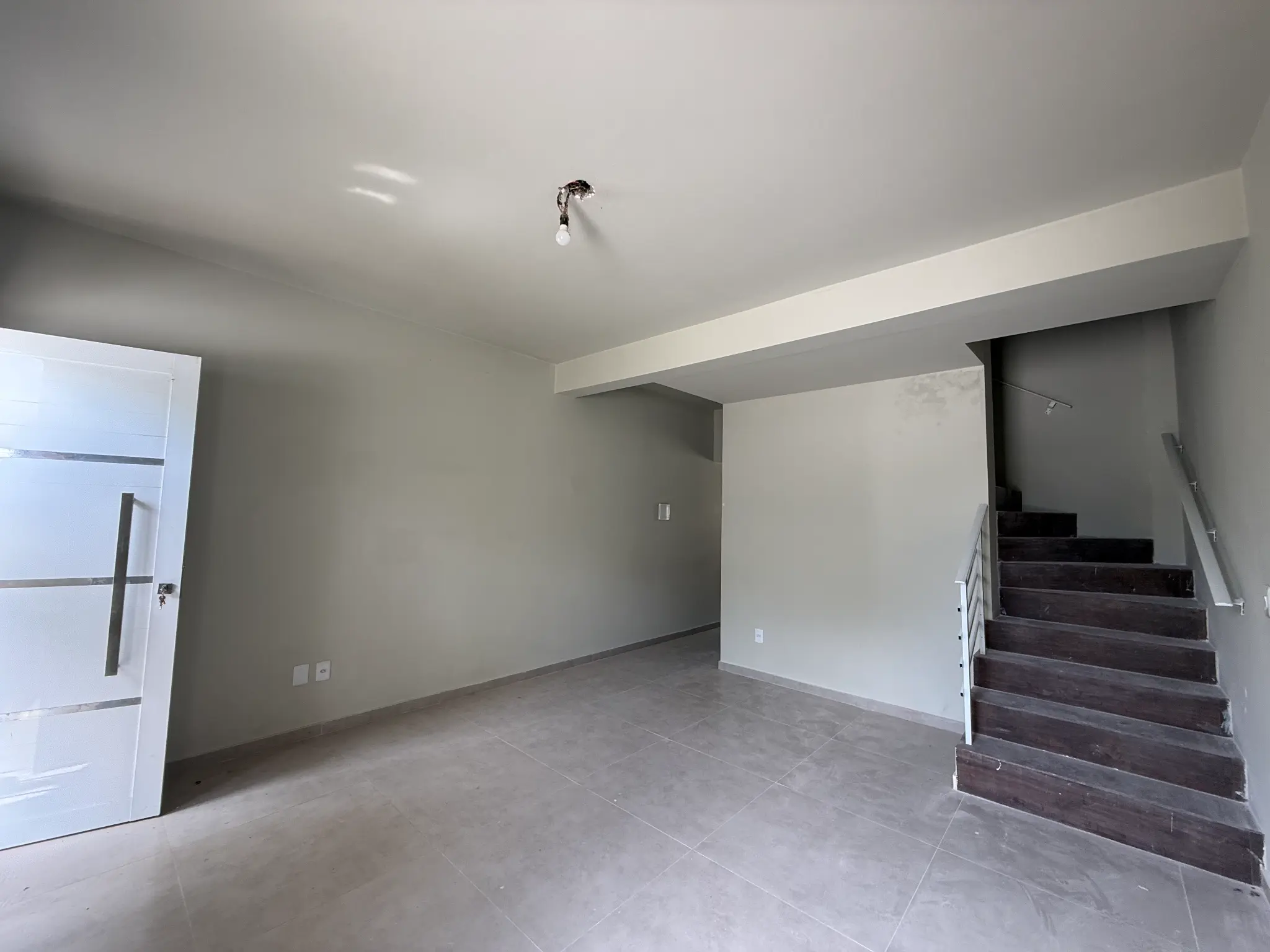 Living amplo com escada de acesso ao segundo piso